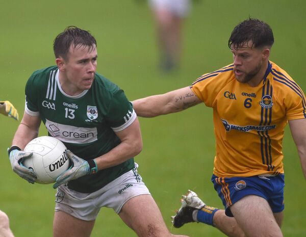 Charlestown’s Paul Towey holds onto possession as Knockmore’s David McHale tries to block his progress. 
