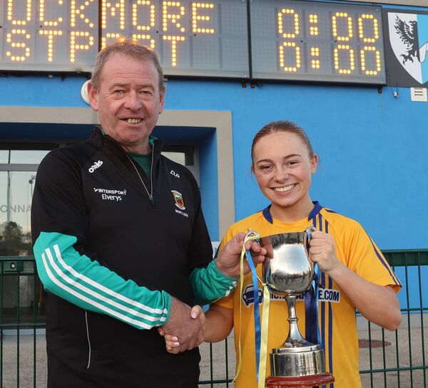 Knockmore captain Nina McVann is presented with cup by Mayo LGFA chairman Des Phillips.