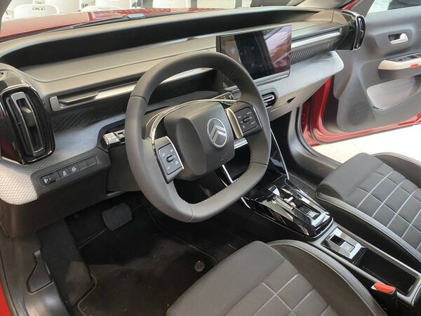 A horizontal fascia stretches across the entire dashboard area, split into two levels, with the technical features above, and a fabric-wrapped section below.