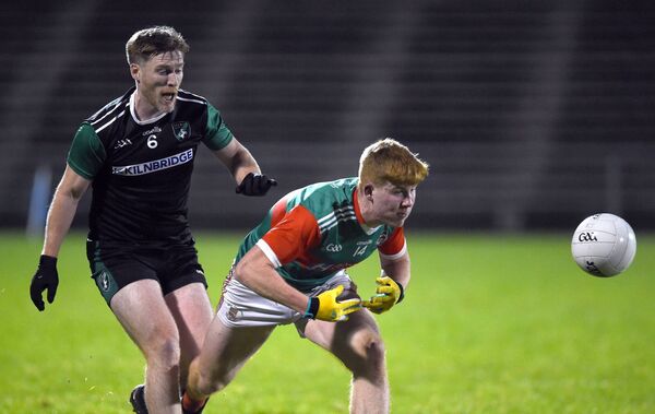 Ballina's Luke Feeney is first to the ball ahead of Fulham Irish defender Michael Clarke.	Picture: David Farrell Photography