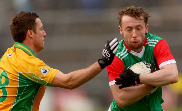 David Tighe of Ballina holds tightly to possession under pressure from Corofin’s Dylan Wall. David Tighe of Ballina holds tightly to possession under pressure from Corofin’s Dylan Wall.