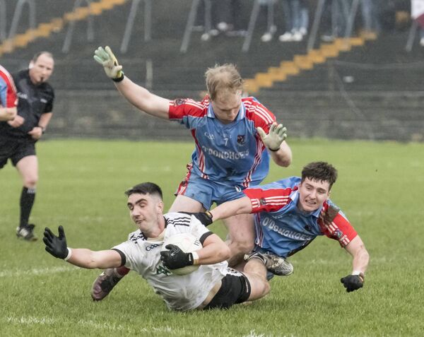 Kilmeena's Keith Joyce is sent sprawling by Keith O'Reilly and Caelom Mulry of Monivea-Abbey