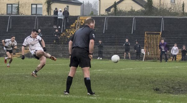 Referee Michael McGirl and some young Kilmeena fans along the sideline watch intently as Darragh Keaveney steps up to the stoppage-time penalty that goalkeeper Denis Farragher saved to send Monivea-Abbey into the final.