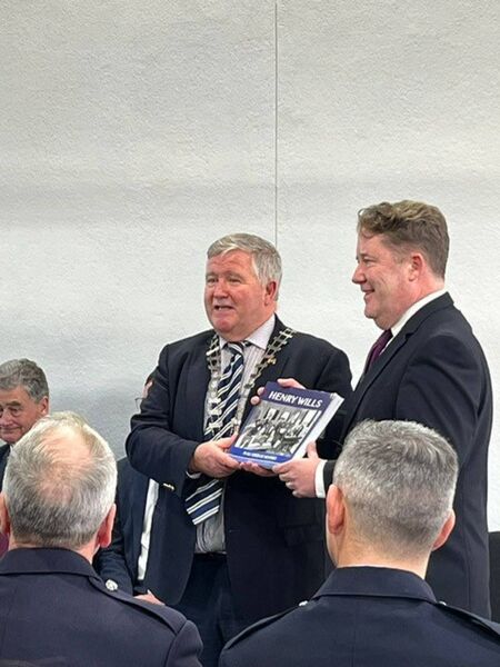 The Cathaoirleach of Mayo Co Council presents a copy of Henry Wills' new book to Minister for Housing Darragh O'Brien during the Minister's recent visit to Ballina and Crossmolina. 