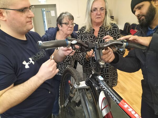 Chris Lynskey, Catherine Osgood, Ann Connolly, and Mohammed Rizwan Ali fine-tuning brakes during a bicycle repair clinic, a popular monthly programme run by Ballyhaunis Community Council.
