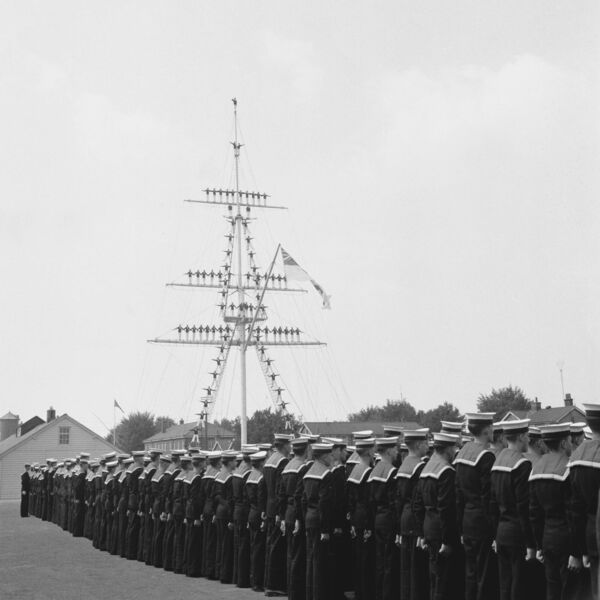 Junior recruits are pictured‘manning the mast’ at HMS Ganges Royal Navy shore establishment at Shotley, Suffolk, while others are lined up on the ground during a visit by Queen Elizabeth II on July 21, 1961. Picture: Evening Standard/Hulton Archive/Getty Images
                    