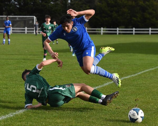 Mayo FC’s Aaron Mujic slide tackles his Limerick opponent. 