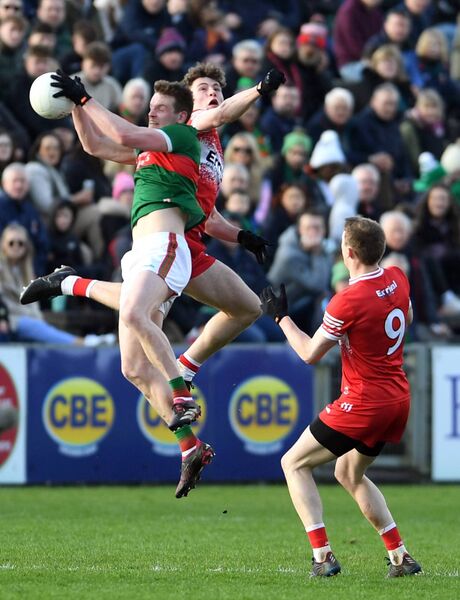 Mayo’s Matthew Ruane grabs the ball in mid air as Derry’s Donnacha Gilmore challenges. Picture: David Farrell Photography 