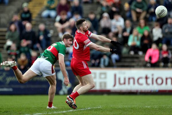 Derry's Niall Loughlin scores a goal despite Mayo's Rory Brickenden putting him under rpessure. Picture: INPHO/Laszlo Geczo