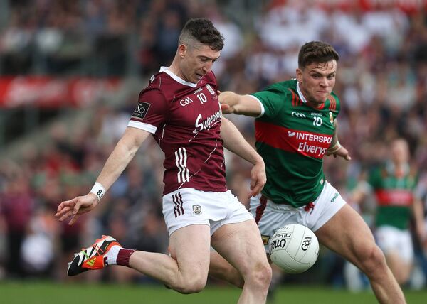 Galway's Johnny Heaney shoots under pressure from Jordan Flynn of Mayo.