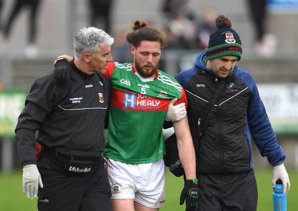 Padraig O’Hora is assisted off the field by club doctor Sean Moffatt and club physiotherapist John Courell after sustaining a head injury. 