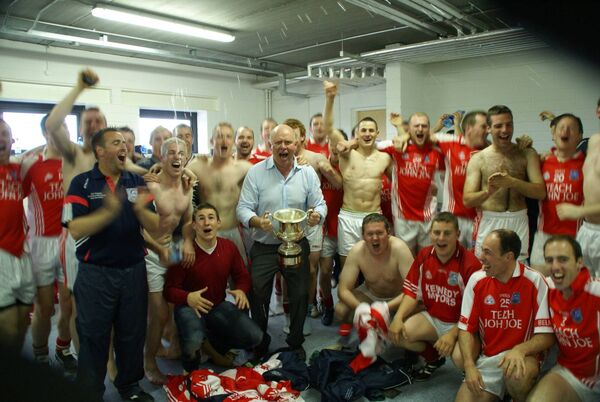 A jubilant Béal an Mhuirthead chairman John Gallagher pictured with the Comórtas cup and the club players in their new dressing room after their 2010 victory on home soil. It was a long journey to that point for Gallagher and the club.	Picture courtesy of John Gallagher 