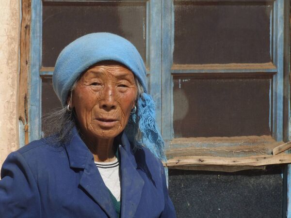 This Chinese woman's colourful outfit somehow belied her age and her world of darkness. Picture: Pat McCarrick This Chinese woman's colourful outfit somehow belied her age and her world of darkness. Picture: Pat McCarrick