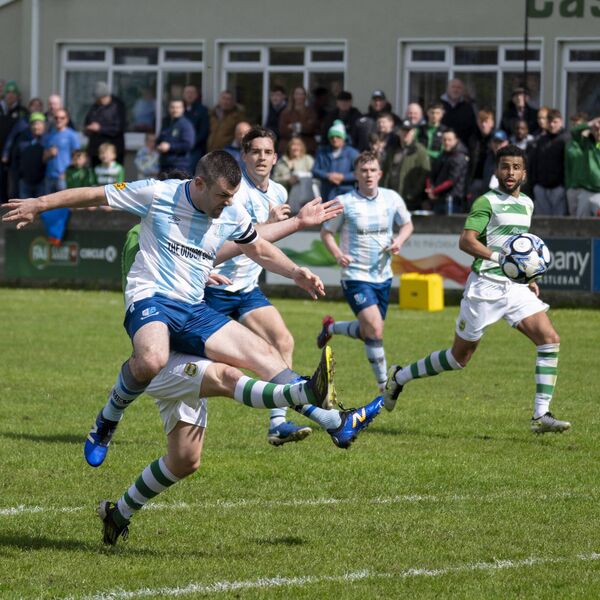 Salthill Devon captain Michael Lee clears away the incoming Castlebar Celtic forward Luke Kelly (mostly hidden). Picture: John Corless