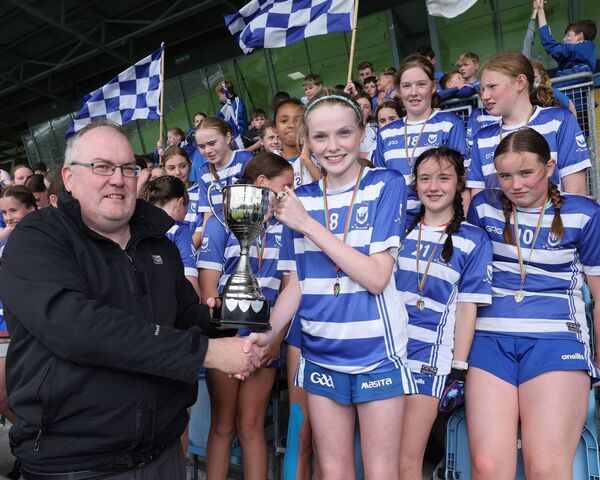 Aoife Connor, captain of Breaffy NS (Castlebar), accepting the cup from Cumann na mBunscol's James Feeney, after victory over St Joseph's NS, Ballinrobe in the Division 1A girls final. Picture: Michael Donnelly
