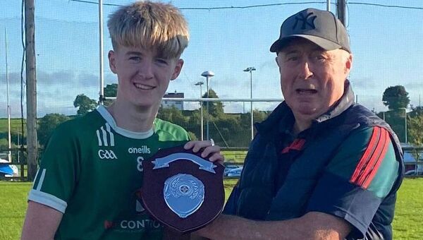 Ryan Rowley victorious captain of the Charlestown Sarsfields U14 team receiving the winners shield from East Board representative Tony Byrne following their victory over Moy Davitts in the East Mayo U14A final.