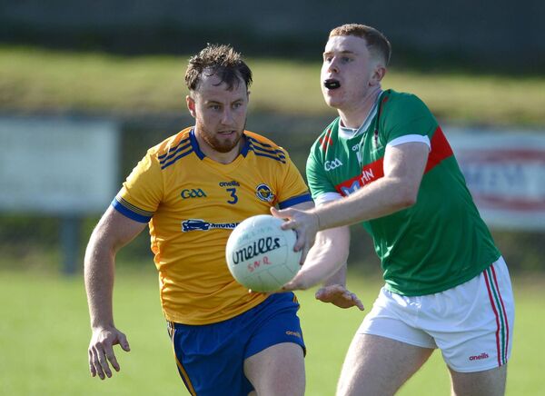 Barry Walsh of Ballina Stephenites is watched closely by Knockmore’s Adam Naughton. Picture: David Farrell Photography