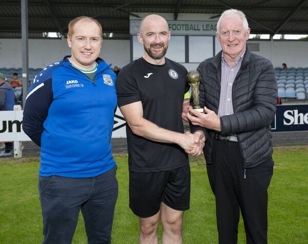 The Player of the Match Award is presented to Joe Slevin of Swinford, by Pat Tonra, with Pat’s son Declan, on the left. 