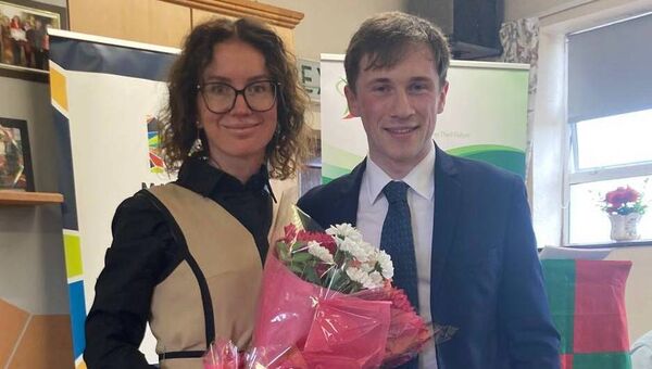 Finian Burke, Chairman of Clogher Community Futures Steering Group, presenting a bouquet of flowers to Katerina Dorofejeva, Community Support worker.