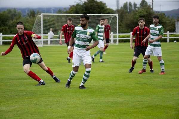 Westport United captain Jack Dawson challenges Jordan Loftus. 