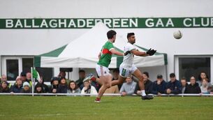 <p>Ballaghaderreen’s Shairoze Akram offloads the ball as Ballina's Ciaran Boland gives chase during last Saturday's Connacht Gold Mayo SFC quarter-final in Ballaghaderreen.	Pictures: David Farrell Photography </p>
