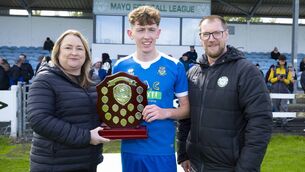 <p>Patricia Craven, daughter of the late Eleanor Quigley presents the Eleanor Quigley Shield to Conor Brett, captain of the victorious Manulla side, with Seamus Hughes, Chairman of the Mayo League. Picture: John Corless</p>