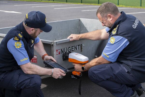 Garda  Alan McGrath assists Sergeant Jonathan Petrie as he etches a trailer at the event. Picture: John Corless