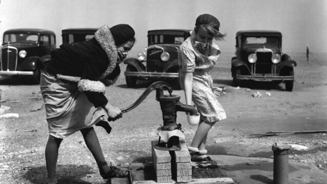 <p>Children cover their faces as they pump water while dust fills the air during a windstorm in Springfield, Colorado, on March 25, 1935. Wind, heat and drought in the 1930s compounded the Great Depression, turning the United States' breadbasket into a dust bowl in the worst weather event of the century. Picture: AP Photo</p>
