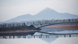 <p>Participants in Castlebar Operation Transformation crossing the pedestrian bridge at Lough Lannagh in 2024. 	Picture: Alison Laredo</p>