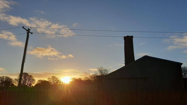 <p>The local creamery's old steam chimney outlined against the setting sun, the only reminder that it was ever a platform for showmen. Picture: Pat McCarrick</p>