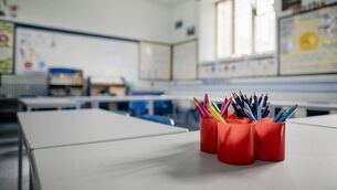 <p>A closeup of an empty classroom with a pot of coloured pencils in red pots. The classroom is in a school in Hexham in the North East of England.</p>