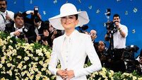 Zendaya sports gold band on her finger as she wears bridal white to fashion show
