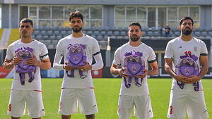 Iran wear black armbands and hold schoolbags during national anthem before match