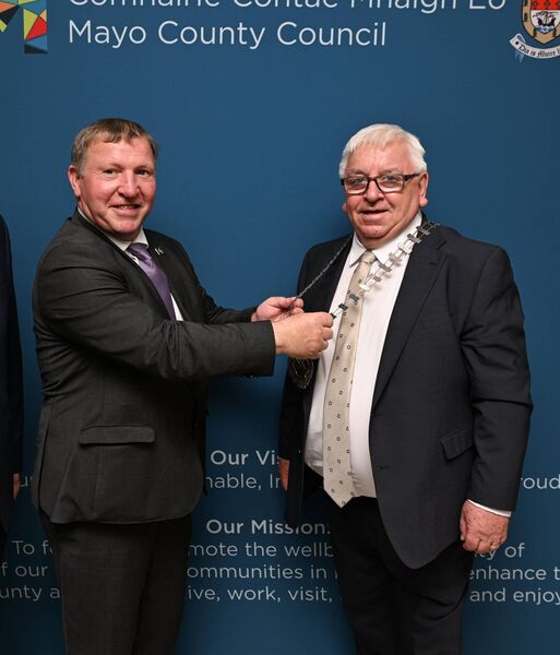 Outgoing Cathaoirleach Sean Carey passes the chain of office to incoming Cathaoirleach Cllr John Caulfield. 