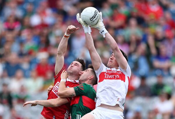 Mayo goalkeeper Jack Livingstone makes a grab for the football under pressure from Cork’s Chris Óg Jones, while Enda Hession is the sandwich in the middle.