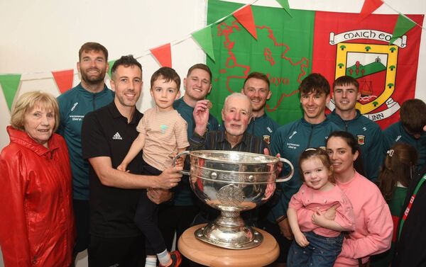 Members of the Courell family, from left, Claire, John, Morgan, Michael (holding his father Gerry's 1936 All Ireland medal), Olivia, and Donna, at Ballina Medical Centre with the Sam Maguire Cup and members of the Mayo team. Picture: John O'Grady