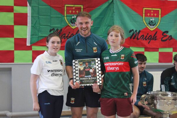 Darren McHale being presented with a book of individual memories and well wishes, written by the children of Breaffy NS, Ballina